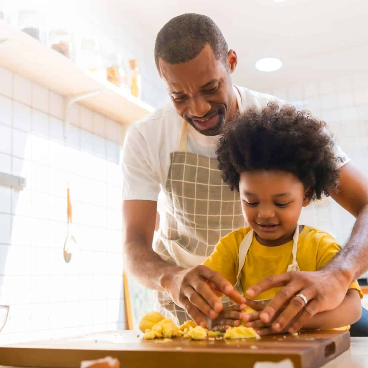 Father and young child baking together in a bright kitchen.